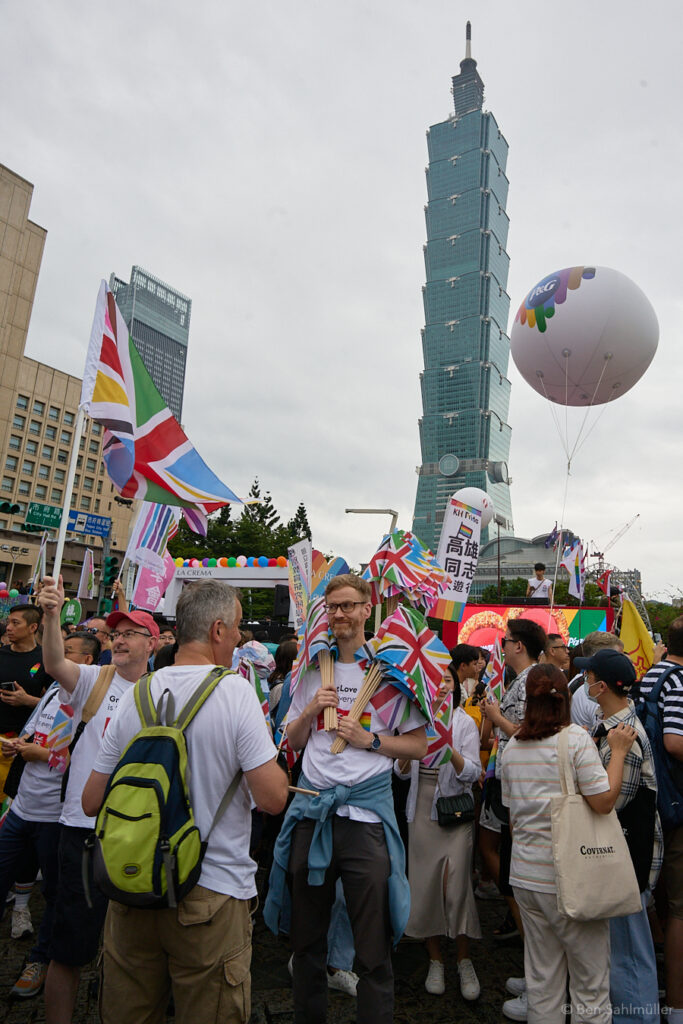Members of the British Office Taipei hold UK-rainbow flags before Taipei 101 at the beginning of Taiwan Pride 2023.